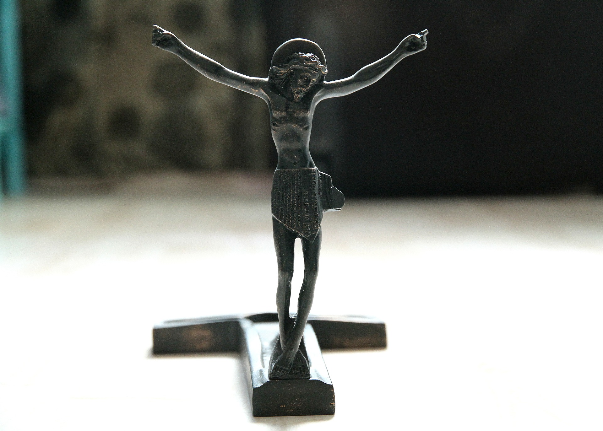 Statue of the Risen Christ, with the cross on the ground behind him at his feet.