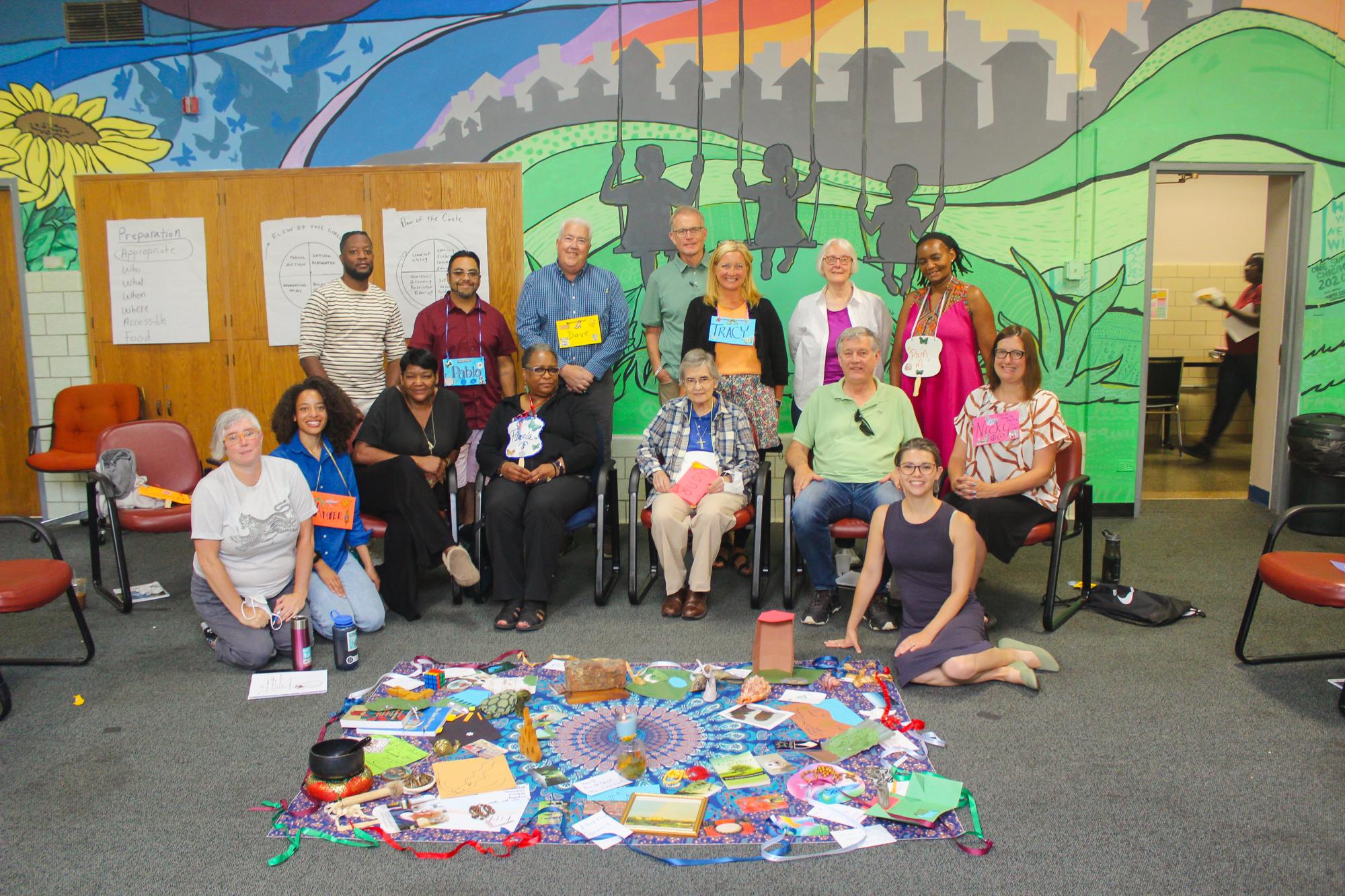 Participants at CMN's annual Circle Keeper Training in Chicago pose alongside the centerpiece to a peacemaking circle.