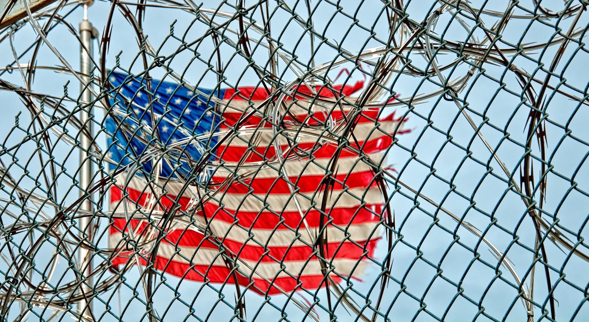 American flag behind barbed wire