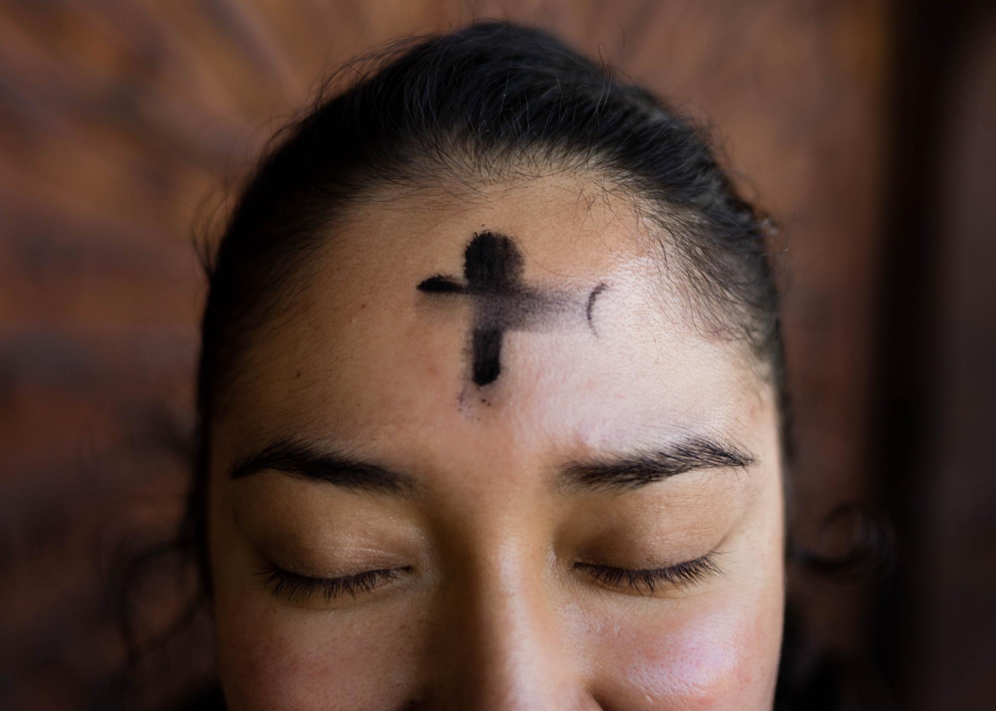 Woman with ash cross on forehead