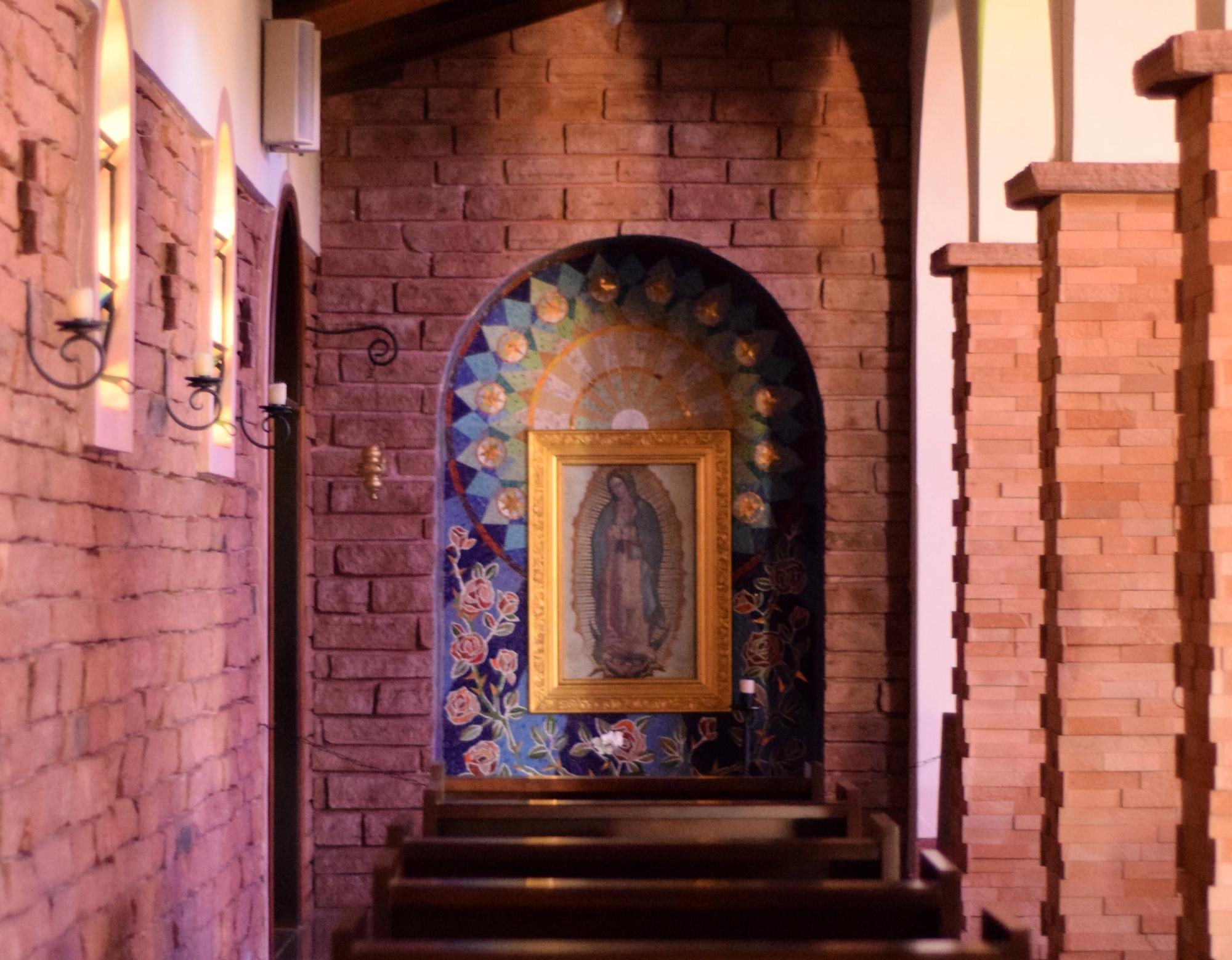 Our Lady of Guadalupe icon hanging on wall in front of church pews