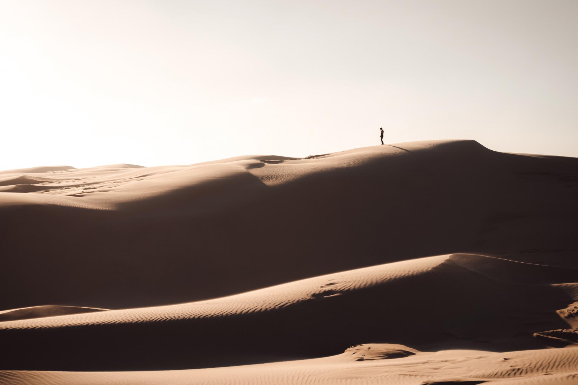 desert sands with person standing on the horizon