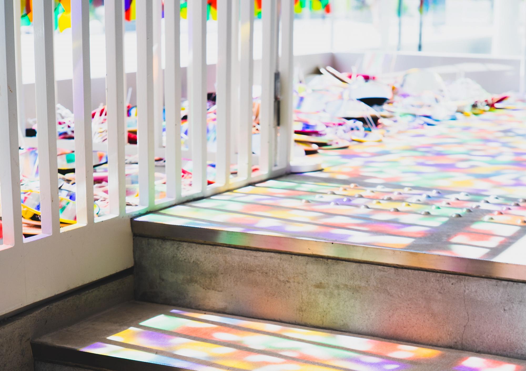 Colored light from stained glass window casted onto staircase