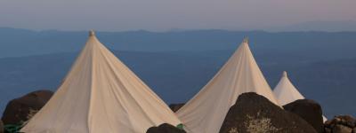 three tents on a mountain top