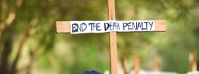 people carrying cross that reads "end the death penalty"