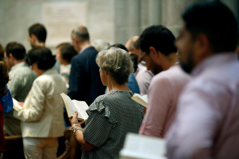 people praying in filled church pews
