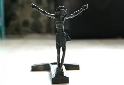 Statue of the Risen Christ, with the cross on the ground behind him at his feet.