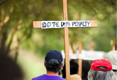 people carrying cross that reads "end the death penalty"