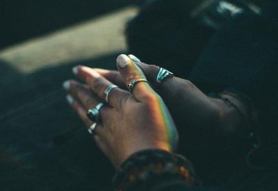 Black hands with rings in prayer position