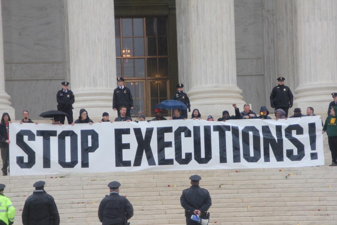 Protesters hold "STOP EXECUTIONS!" sign on the steps of the supreme court